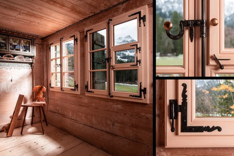Holzfenster mit traditionellem Beschlag in einer Holzfassade