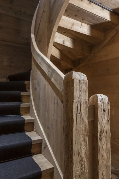 Detail einer Holztreppe mit ausgearbeitetem Handlauf